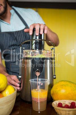 Shop assistant preparing fruit juice