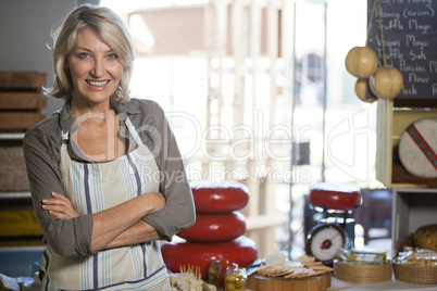 Portrait of female staff standing with arms crossed at counter