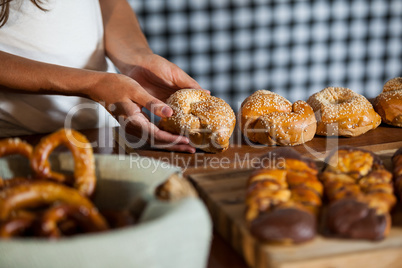 Mid-section of woman holding bread at counter