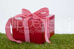 Red gift box on green grass