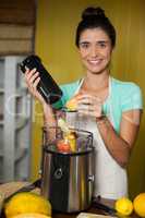 Portrait of smiling shop assistant preparing juice