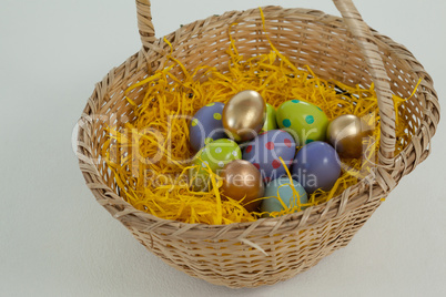 Various Easter eggs in wicker basket