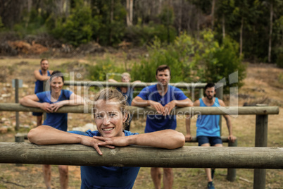 Group of people leaning on hurdles during obstacle training