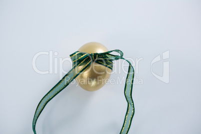 Golden Easter egg tied with ribbon on white background