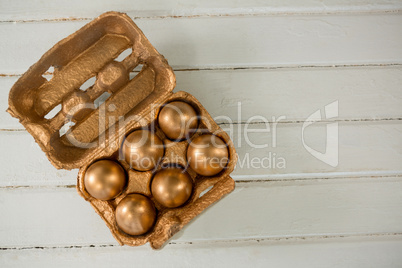 Golden Easter eggs in the carton