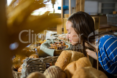 Smiling woman smelling a bakery snacks at counter