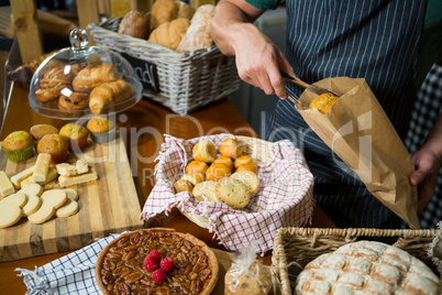 Male staff packing cookies in paper bag