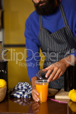 Male staff closing the lid of juice glass at counter
