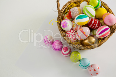 Basket with painted Easter eggs on white background
