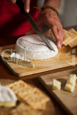 Staff cutting cheese at counter in market