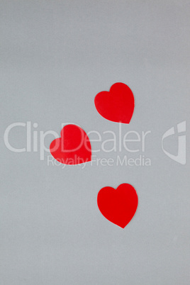 Three red hearts on grey background