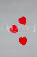 Three red hearts on grey background