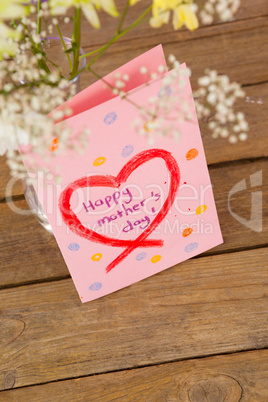 Happy mothers day card with flower vase on table