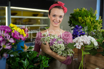 Female florist holding bunch of flower in flower shop