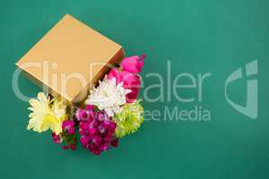 Gift box full of flower against green background