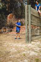 Man standing while woman sitting over wooden wall