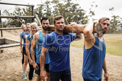 People carrying a heavy wooden log during boot camp