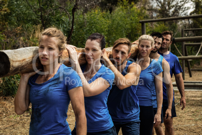 People carrying a heavy wooden log during boot camp