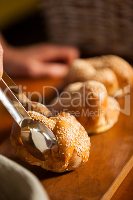 Hand of female staff holding sweet food with tongs