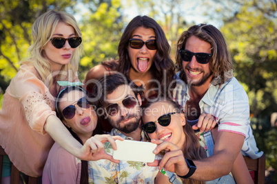 Group of friends taking selfie with mobile phone