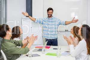 Executives appreciating their colleague during presentation in conference room