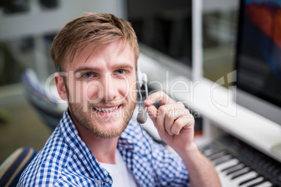 Portrait of male customer service executive talking on headset at desk