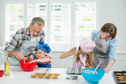 Parents and kids preparing cookies in kitchen