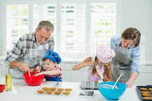 Parents and kids preparing cookies in kitchen