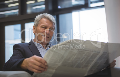 Businessman reading newspaper while sitting