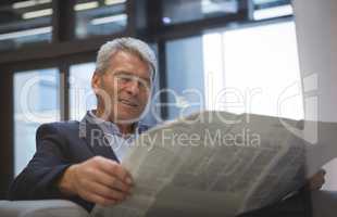 Businessman reading newspaper while sitting