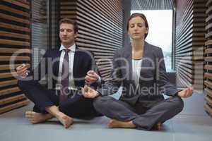 Businesspeople performing yoga in the corridor