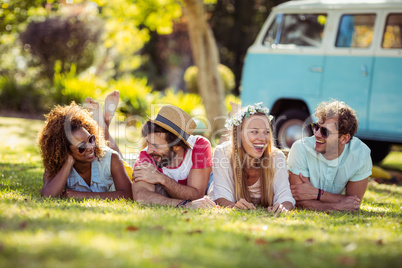 Happy friends lying on grass together