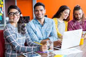 Smiling graphic designers discussing over laptop in meeting