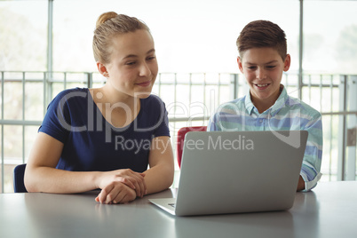 School kids using laptop in library