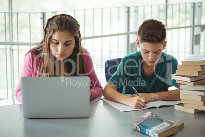School kids doing homework in library
