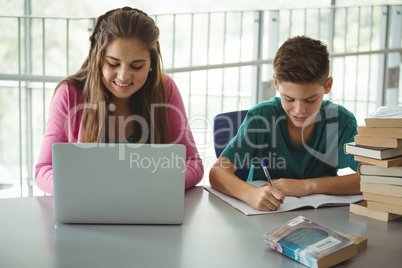 School kids doing homework in library