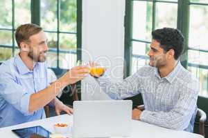 Happy executives toasting glasses of juice