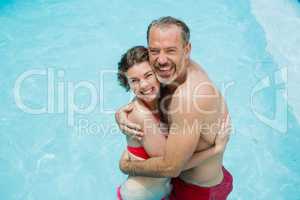 Portrait of romantic couple embracing in smiling pool