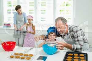 Father and son preparing cookies in kitchen