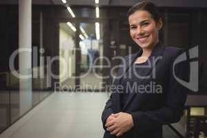 Beautiful businesswoman standing in corridor of office