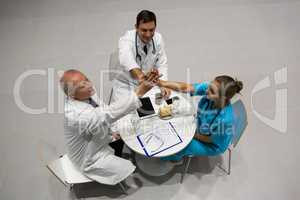 High angle view of doctors and surgeon giving high five to each other