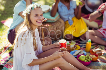 Portrait of woman sitting with coffee cup and cupcake