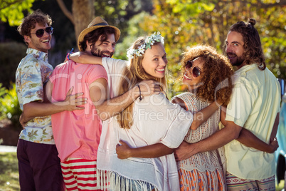 Happy friends standing together with arms around Happy friends standing together with arms around