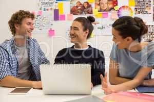 Executives discussing over laptop in office