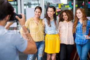 Man photographing his female colleagues with camera