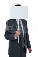 Businessman covering his face behind blank placard