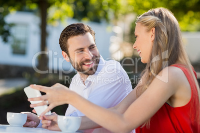 Couple using mobile phone in a restaurant