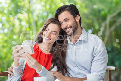 Smiling couple taking a selfie while sitting