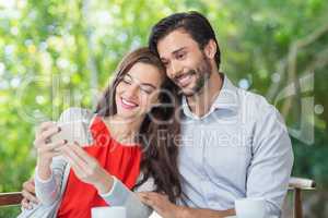 Smiling couple taking a selfie while sitting