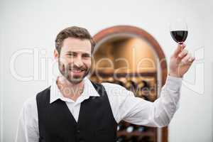 Male waiter holding wine glass in the restaurant